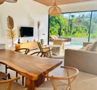 Einfamilienhaus mit Holzboden, geflochtenen Lampen und Blick auf die Natur.