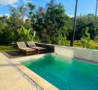 Ein Swimmingpool in einem Einfamilienhaus in Amed, umgeben von Grün und blauem Himmel.