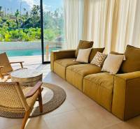 Wohnzimmer eines Einfamilienhauses mit großem Fenster, Blick auf den Garten und Pool.