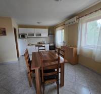 Esszimmer mit Tisch, Stühlen und Küchenzeile in besonderen Immobilien.