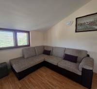 Ein Sofa in der Ecke des Zimmers mit einer Sitzgarnitur, Holzboden, Wandbild.