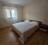 Schlafzimmer mit heller Wand, Bett und Boden mit Holzdekor in besonderen Immobilien.