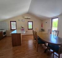 Esszimmer und Küche mit hellen Wänden, Holzboden und Möbeln.