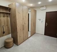 Der Flur in der 2-Zimmer-Wohnung mit Möbeln in Holzoptik und einem eingebauten Spiegel.