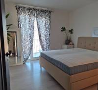 Schlafzimmer mit großem Bett, Pflanzen, Spiegel und Vorhängen in einer 3-Zimmer-Wohnung.