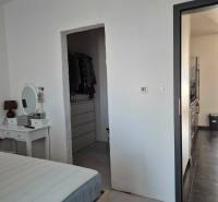 Schlafzimmer mit Spiegel, Zugang zum Kleiderschrank und Flur in einer 3-Zimmer-Wohnung.