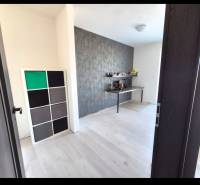 Ein Zimmer in einer 3-Zimmer-Wohnung mit einem Boden in Holzoptik und einer dekorativen Wand.