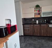 Küche in einer 3-Zimmer-Wohnung mit modernen Geräten und dekorativem Holz.