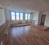 Geschäftsräume mit Holzboden und großen Fenstern.