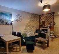 Wohnzimmer mit Holzboden und stilvollen Sitzgelegenheiten in einer 3-Zimmer-Wohnung.