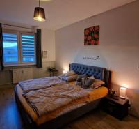 Schlafzimmer mit Doppelbett, Schreibtisch und Boden mit Holzdekor in einer 3-Zimmer-Wohnung.