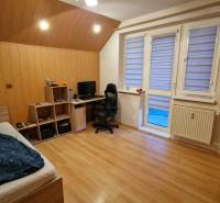 Schlafzimmer in einer 3-Zimmer-Wohnung mit Holzboden, Schreibtisch und Bett.