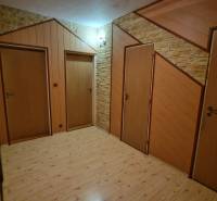 Ein Flur mit drei Türen und einem Boden in Holzoptik in einer 3-Zimmer-Wohnung.