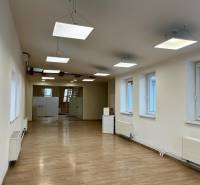 Büros mit Holzboden, Pendelleuchten und Glastüren.