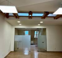 Innenraum eines Büros mit Holzboden und Glastüren.