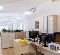 Büros mit Holzboden, Schreibtischen und Lagerschränken.