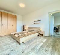 Helles Schlafzimmer mit Holzboden, Bett und Schrank in einer 2-Zimmer-Wohnung in der Východná-Straße.