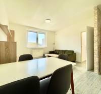 Wohnzimmer in einer 2-Zimmer-Wohnung mit Holzboden, Sofa und Esstisch.