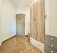 Eingangsflur mit Fliesen, großem Schrank und Sicherheitstür in einer 2-Zimmer-Wohnung in der Východná-Straße.