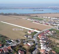 Grundstücke zum Wohnen in Sokolovce, umliegende Landschaft mit Wasserfläche im Hintergrund.
