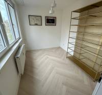 Izba v 2-izbovom byte s poličkou, podlahou s dreveným dekorom a oknom.