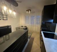 Küche in einer 2-Zimmer-Wohnung mit Glasleuchten und einem Boden in Holzoptik.