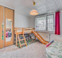 Kinderzimmer mit Etagenbett, Schränken und bunten Stühlen in einer Vierzimmerwohnung.