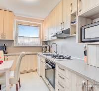 Küche in einer 4-Zimmer-Wohnung mit Obst auf dem Tisch und eingebauten Geräten.