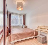 Schlafzimmer in einer 4-Zimmer-Wohnung mit Bett, Schreibtisch und Boden in Holzoptik.