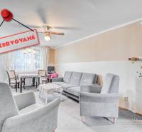 Wohnzimmer in einer 4-Zimmer-Wohnung mit bequemen Sesseln und einem Essbereich.