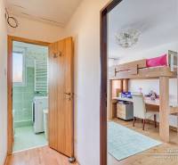 Flur mit Badezimmer und Kinderzimmer in einer 4-Zimmer-Wohnung, Boden mit Holzdekor.