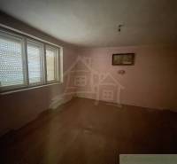 Ein leerer Raum in einem Einfamilienhaus mit Holzboden und einem großen Fenster.