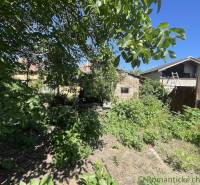 Der Garten beim Einfamilienhaus in Tvrdošovce, umgeben von üppigem Grün und Bäumen.