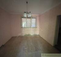 Ein Raum in einem Einfamilienhaus mit rosa Wänden und einem Boden in Holzoptik.