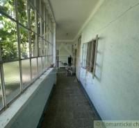 Ein schmaler verglaster Raum in einem Einfamilienhaus mit Blick auf den Garten.