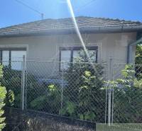 Ein Einfamilienhaus in Tvrdošovce mit einem Zaun und Grünflächen, klarer sonniger Himmel.