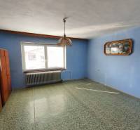 Ein Interieur in einem Einfamilienhaus mit blauer Wand, Teppich und Hängelampe.