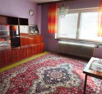 Lila Wände und ein luxuriöser Kronleuchter schmücken den Raum in einem Einfamilienhaus mit einem auffälligen Teppich.