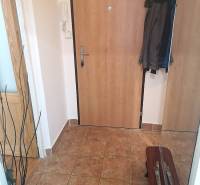 Eingangsbereich einer Zweizimmerwohnung mit Keramikboden und Jacken an der Garderobe.