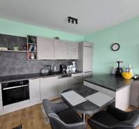 Küche mit Esstisch und Boden in Holzoptik im Ferienapartment.