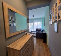 Eine Halle in einem Ferienapartment mit einem Holzboden und einem Spiegel an der Wand.