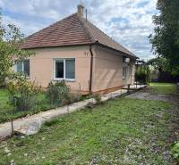 Ein Einfamilienhaus in Komárno mit einem Rasen im Garten und Bäumen auf einem gepflegten Grundstück.