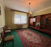 Wohnzimmer mit Teppich und Möbeln in einem Einfamilienhaus, sanft beleuchtet von einem Kronleuchter.