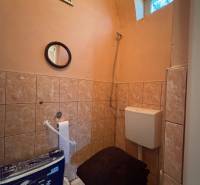 Toilette mit Fliesen, Spiegel und Belüftung in einem Einfamilienhaus.