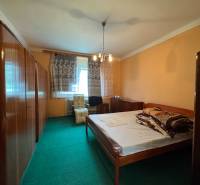 Schlafzimmer in einem Einfamilienhaus mit Teppichboden und Holzmöbeln.