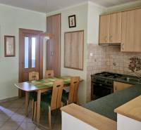 Küche in einer 3-Zimmer-Wohnung mit Esstisch und Holzschränken.