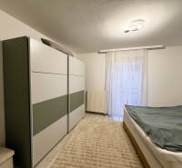 Schlafzimmer in einer 3-Zimmer-Wohnung mit Schrank, Bett und Boden mit Holzdekor.