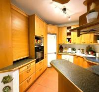 Küche in einer 3-Zimmer-Wohnung mit Eckküche und Boden in Holzoptik.