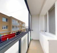 Der Balkon einer 4-Zimmer-Wohnung in Hlboké mit Blick auf das Nachbargebäude und einen Wäscheständer.