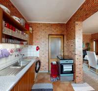 Küche mit Herd und Esstisch in einer 4-Zimmer-Wohnung mit Holzboden.